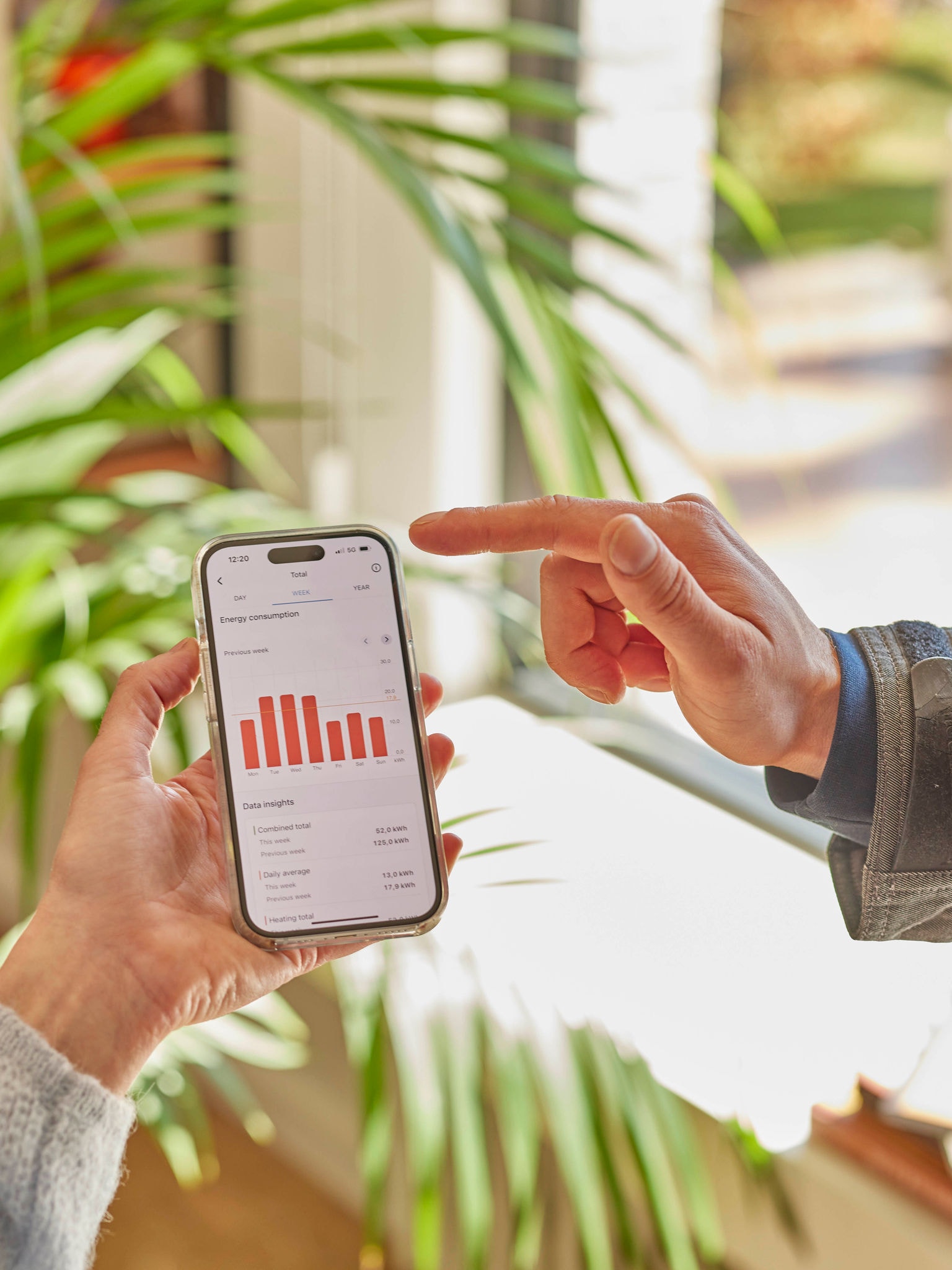 Due persone esaminano insieme i dati sulle prestazioni della pompa di calore su un'app per smartphone