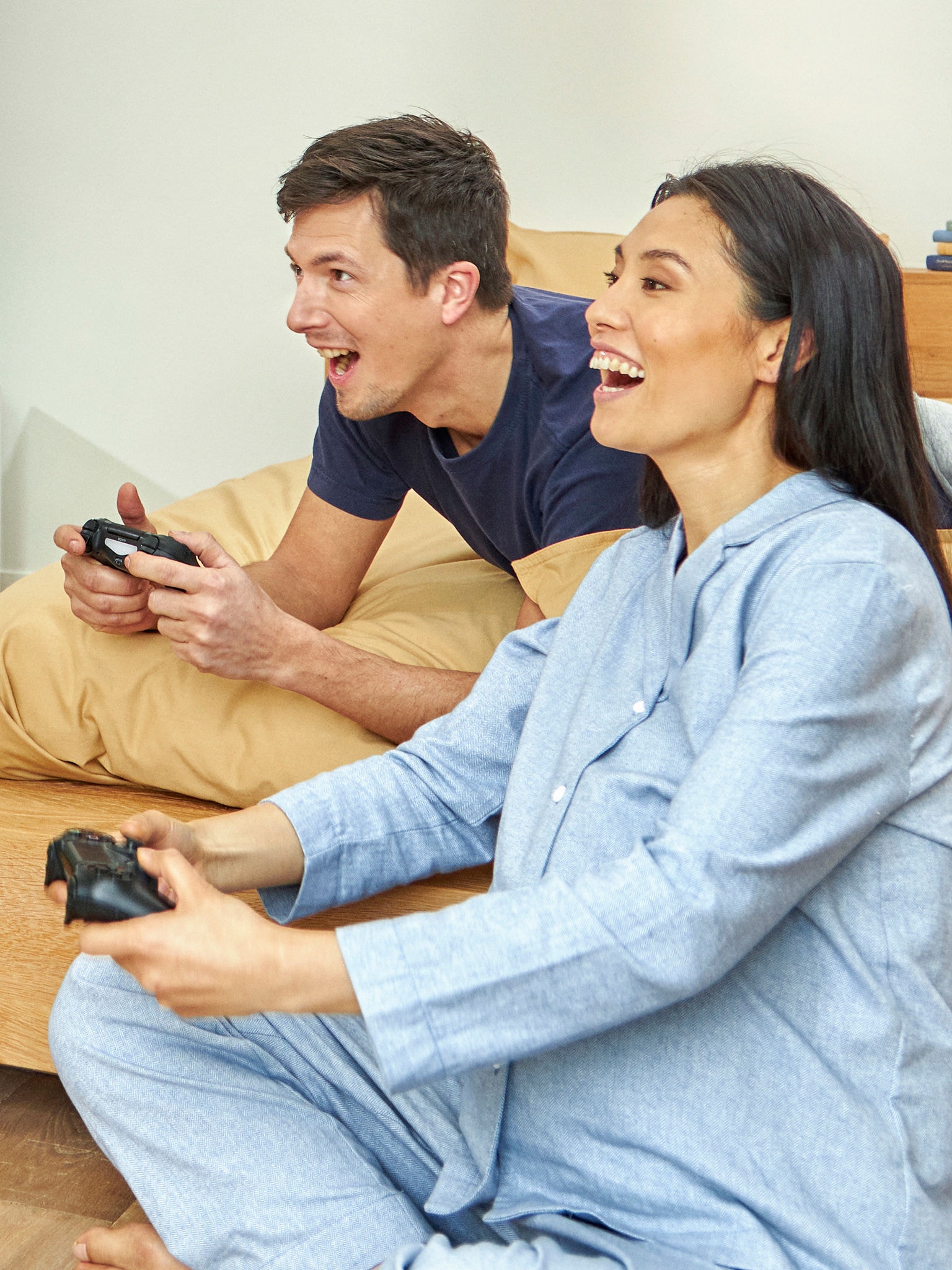 Una coppia gioca a un videogame in pigiama in una casa ventilata