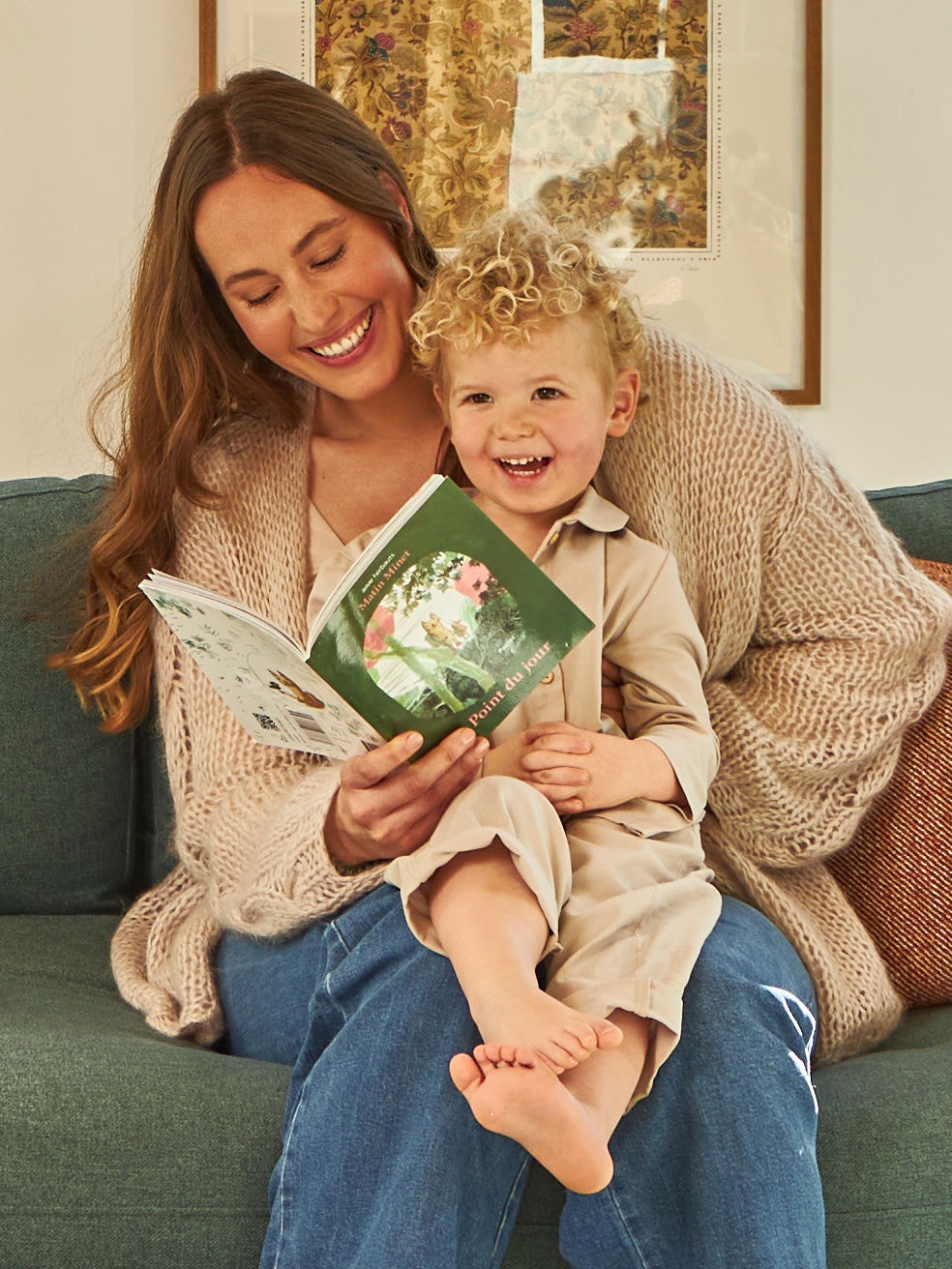 Una madre con un bimbo in braccio sfoglia un libricino