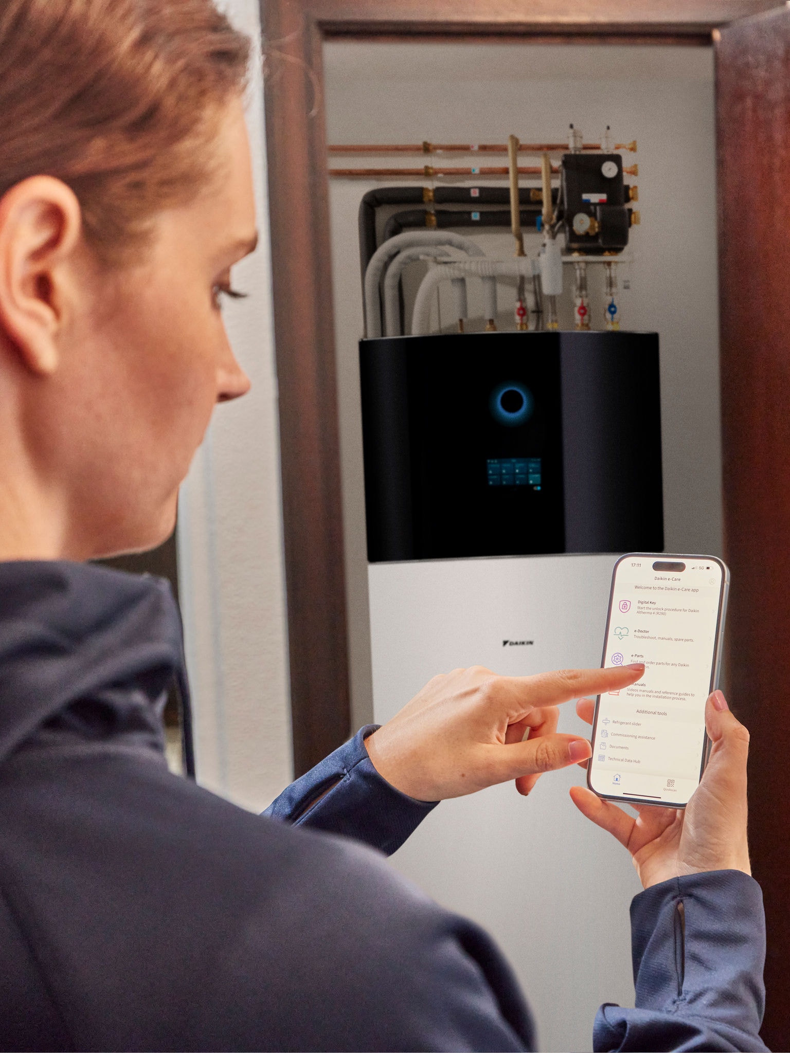 Donna che controlla la sua pompa di calore a distanza tramite smartphone in una casa moderna