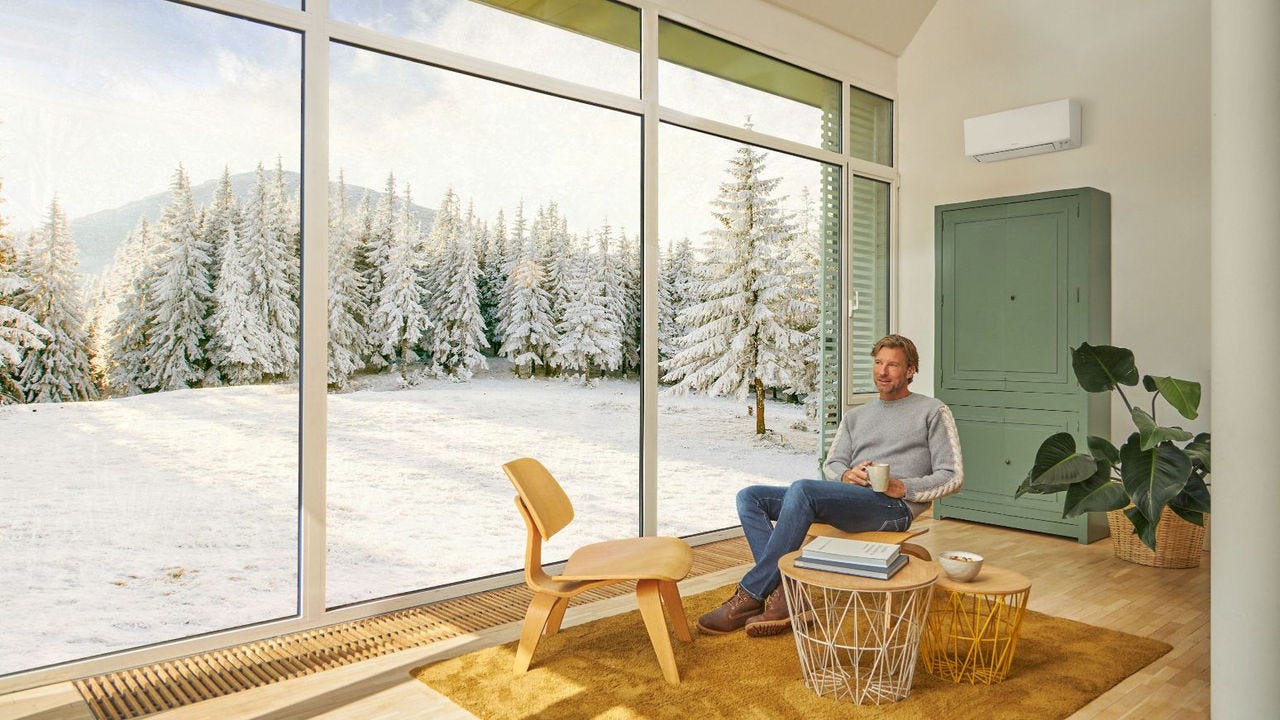 Un uomo seduto sul divano si gode il riscaldamento fornito dal climatizzatore