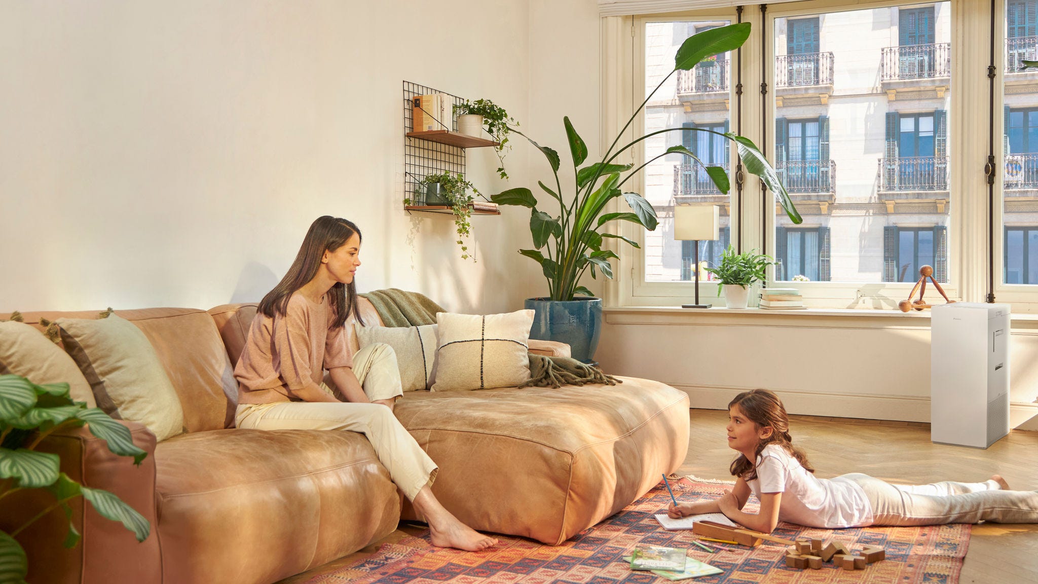 Mamma e figlio a casa con un purificatore aria che riduce gli allergeni all’interno e migliora la qualità dell'aria