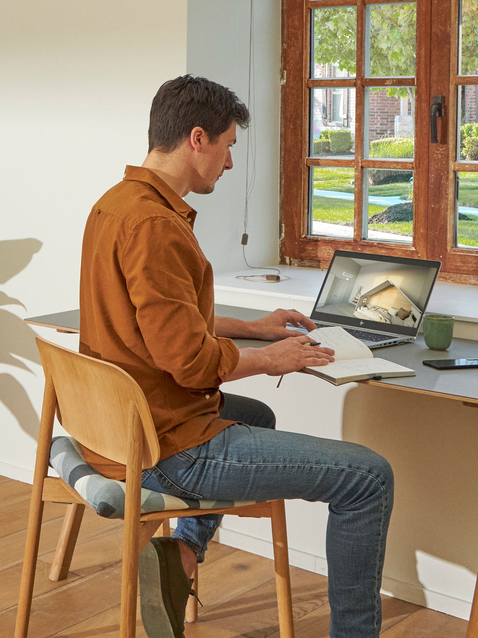 Un uomo seduto alla scrivania guarda i climatizzatori nel centro di esperienza virtuale sul suo computer portatile