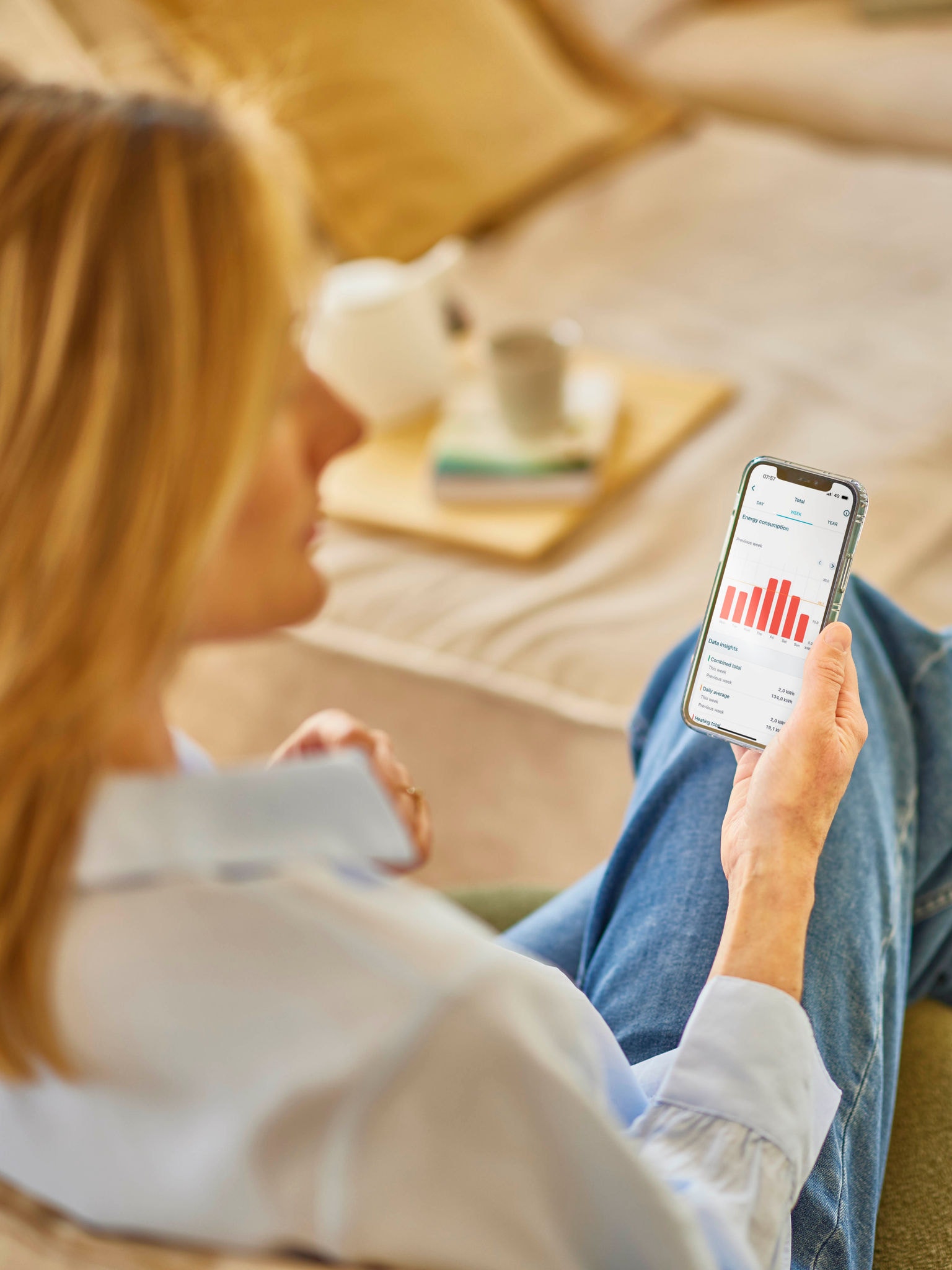 Una donna bionda controlla i consumi energetici su un'applicazione del telefono