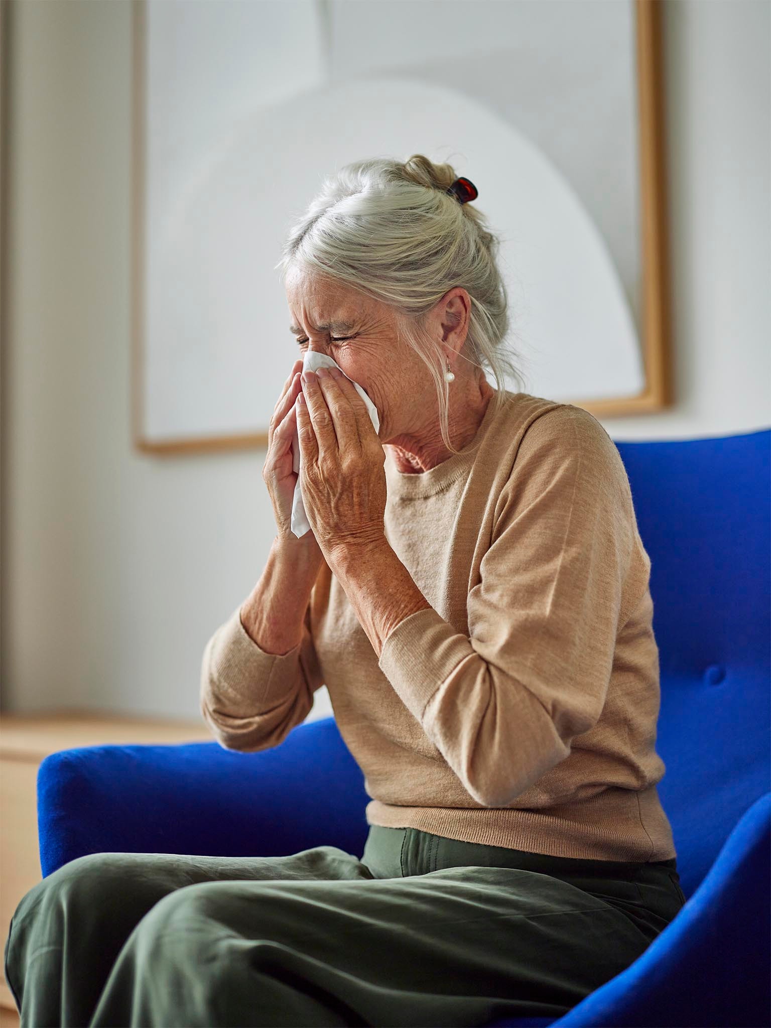 Una donna starnutisce per via delle allergie