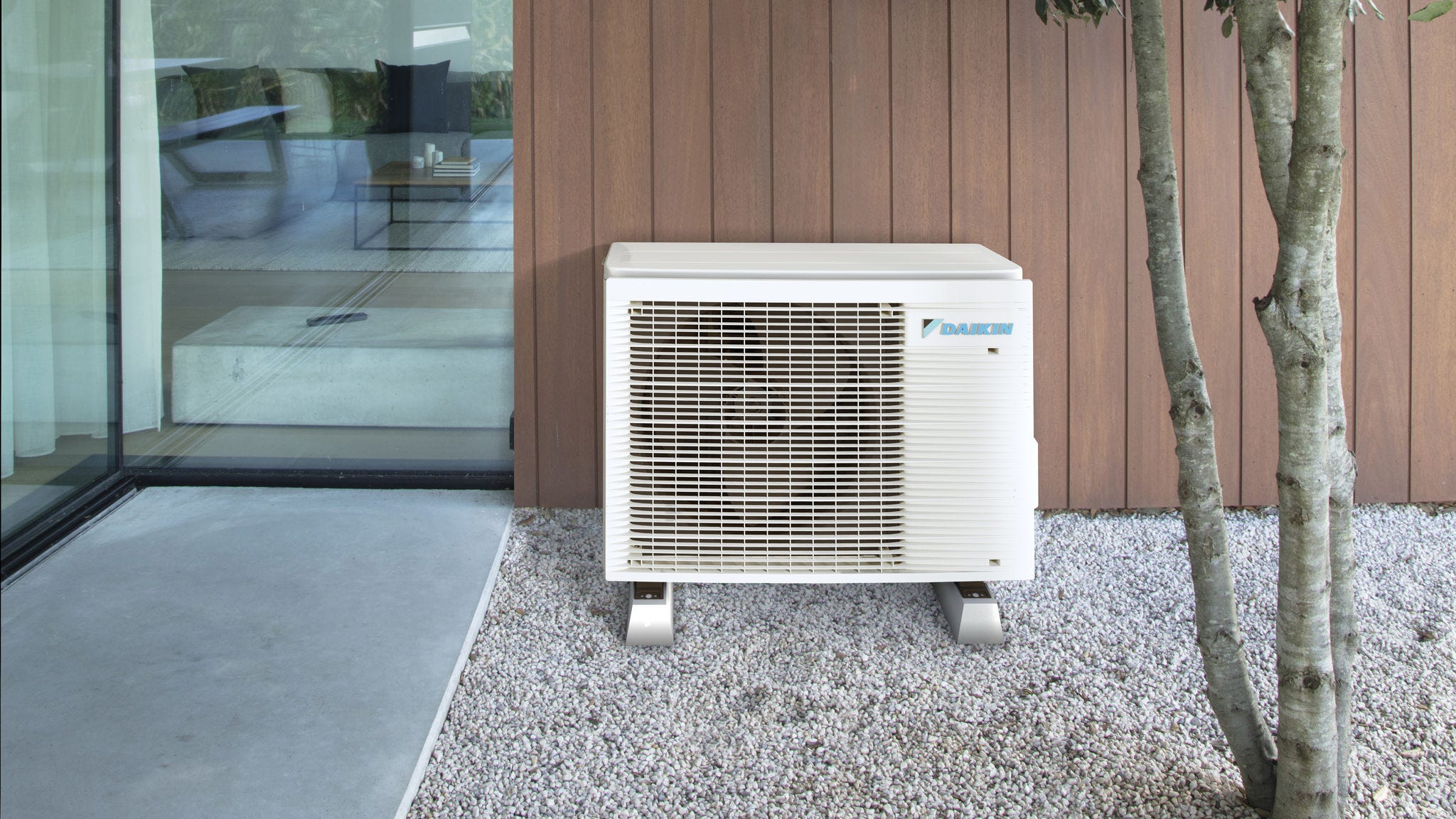 Una pompa di calore ad aria compatta installata discretamente all’esterno accanto a una casa moderna