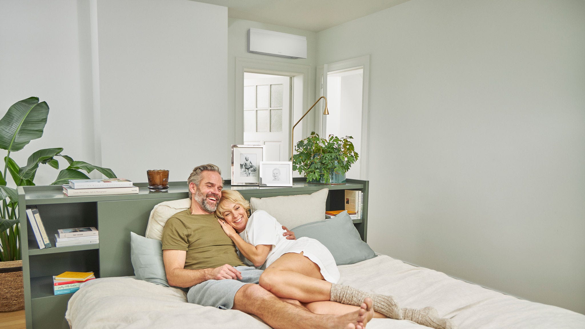 Coppia che si rilassa sul letto in una camera da letto fresca con un climatizzatore silenzioso