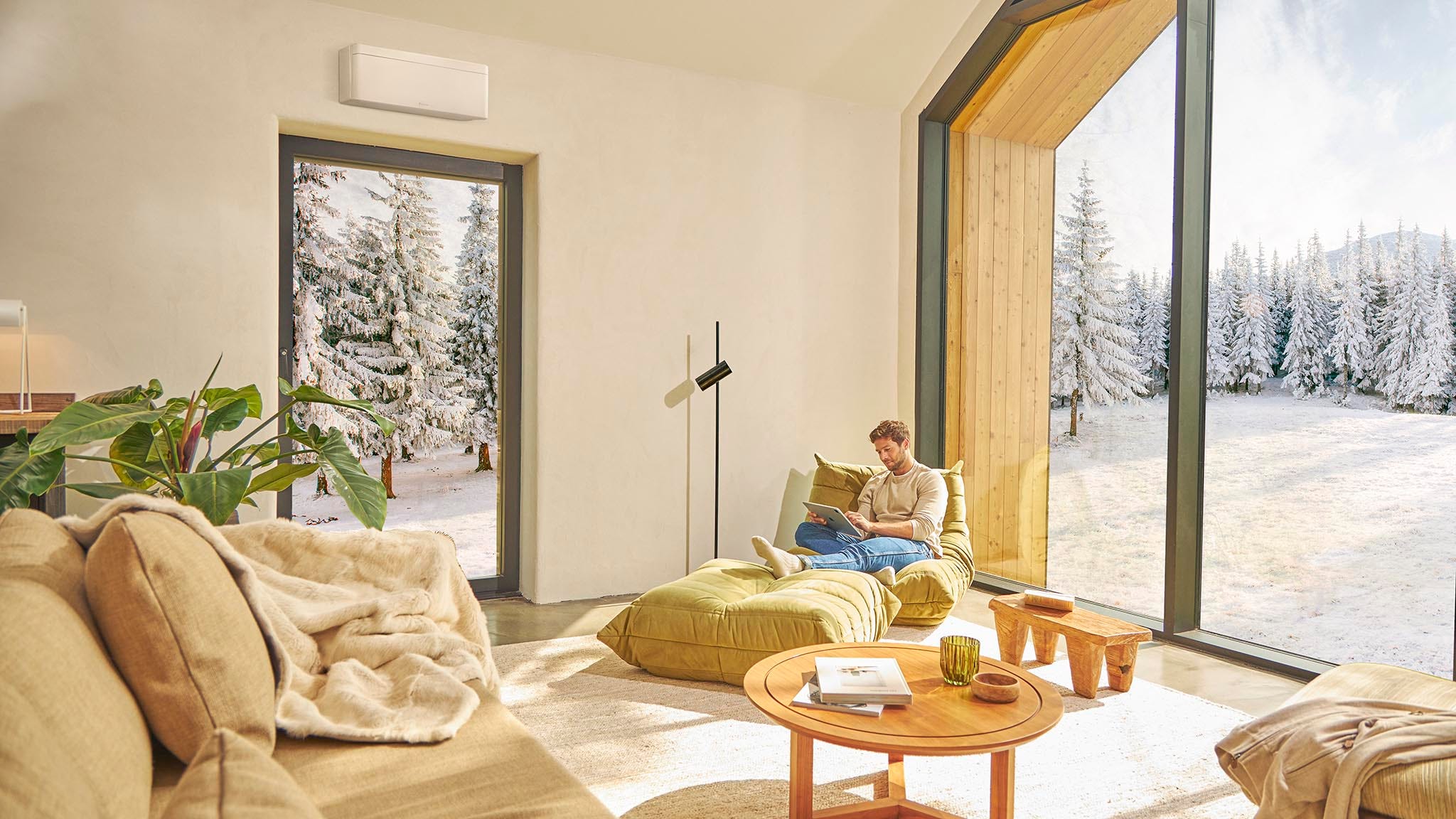 Un uomo seduto sul divano si gode il riscaldamento fornito dal climatizzatore